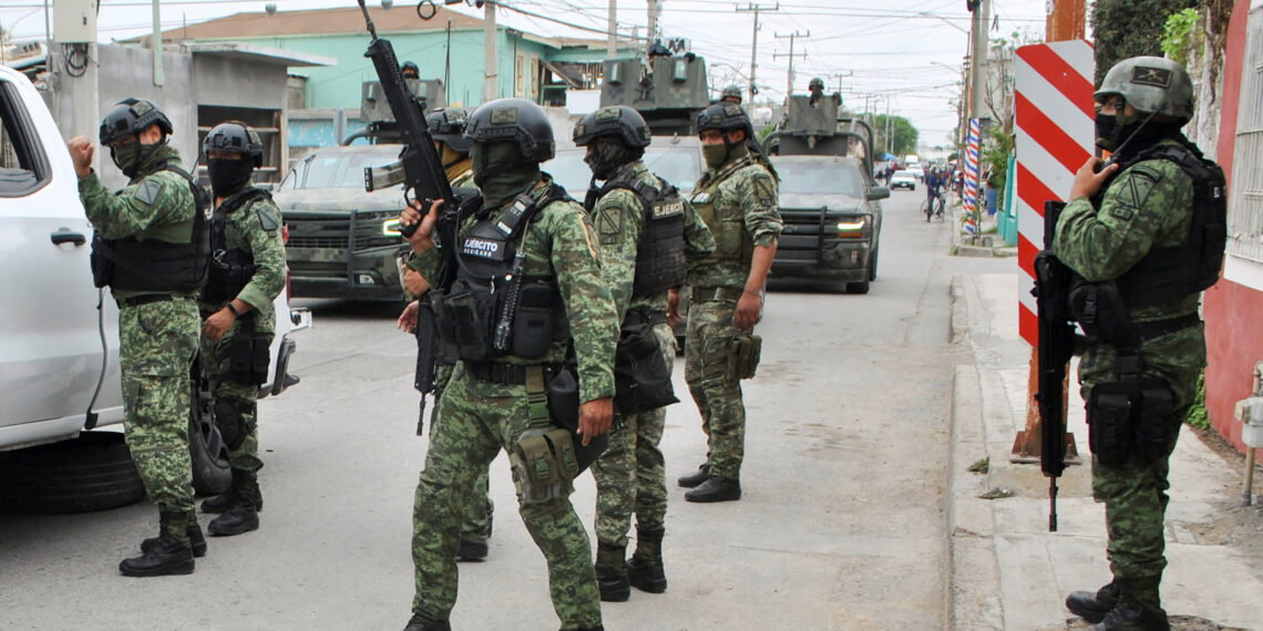 Mexican soldiers stand guard after being accused by people, of having participated with other military members in the shooting deaths of five people, in Nuevo Laredo, Mexico February 26, 2023. REUTERS/Jasiel Rubio NO RESALES. NO ARCHIVES