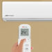 Women hand using remote control the air conditioner is cooled to 25 degrees Celsius for energy saving.