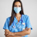 Portrait of Latin American nurse wearing protective face mask. Female healthcare worker is with stethoscope during COVID-19. She is against gray background.